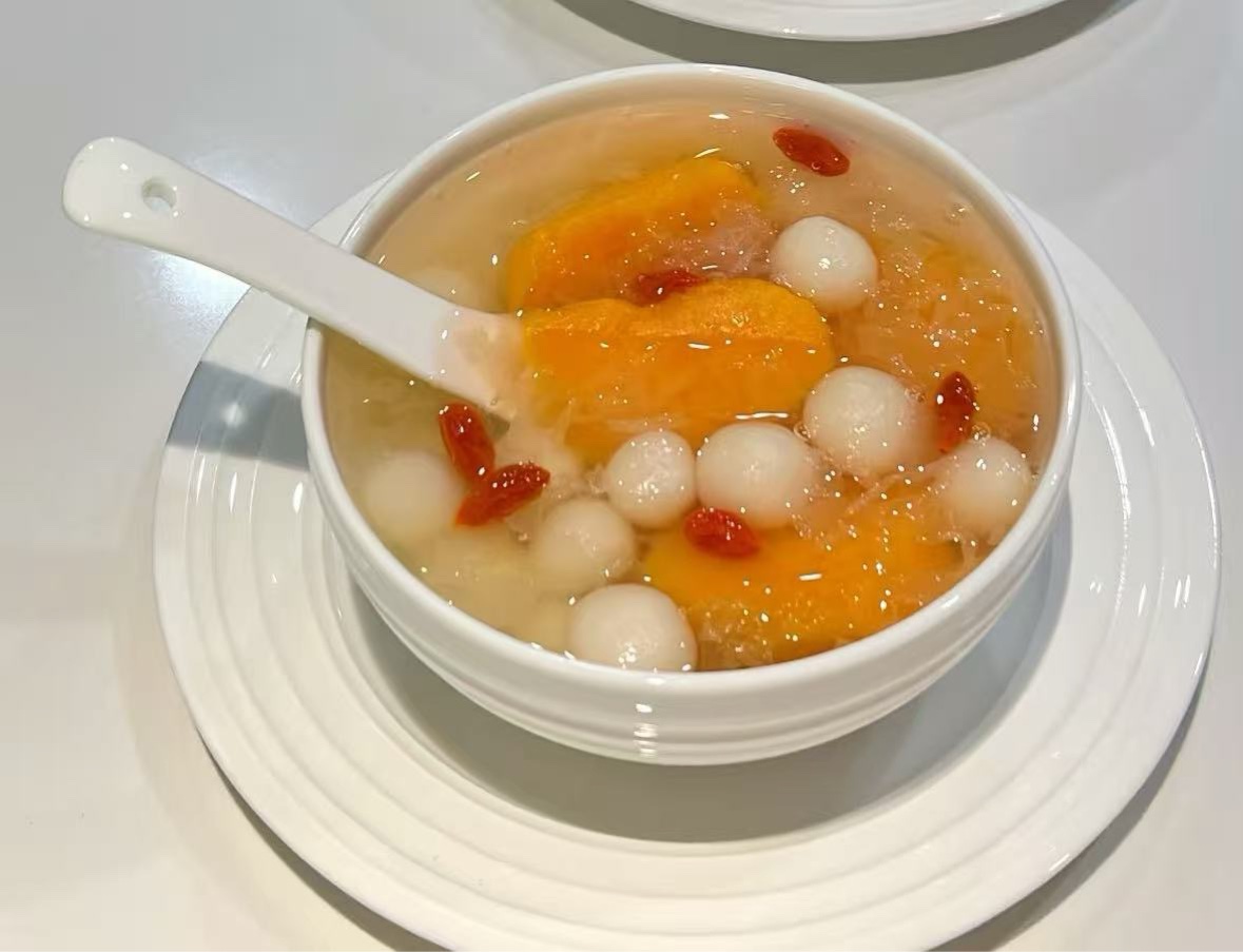 Orange sweet soup with glutinous rice balls and goji berries